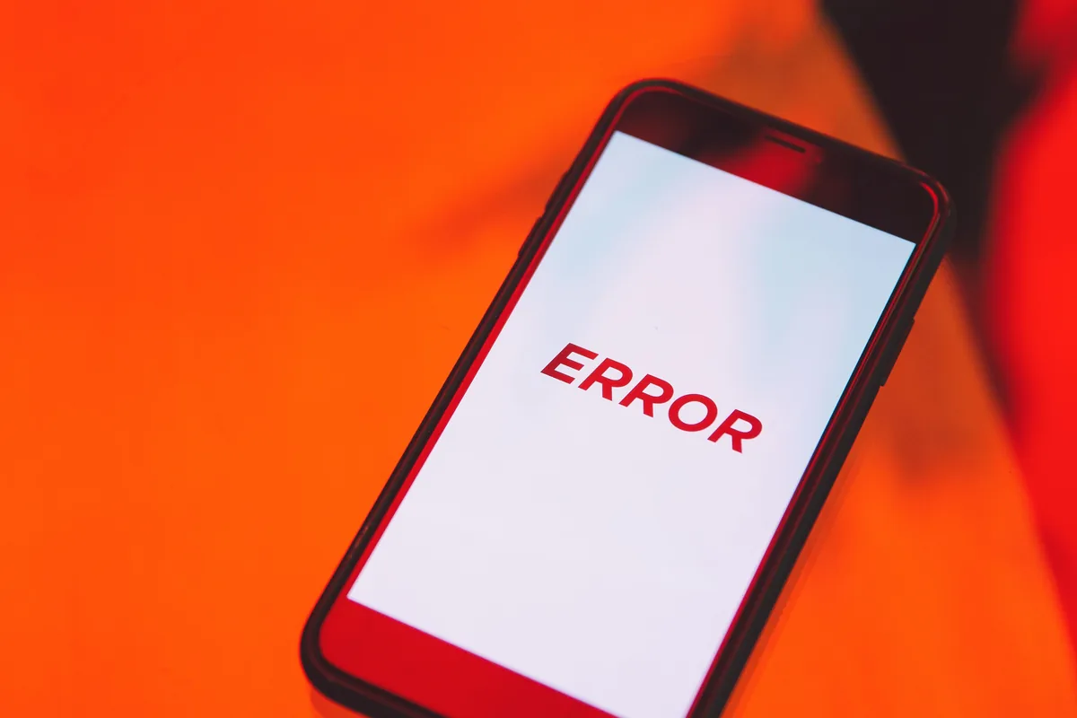 Smartphone mit der Anzeige &bdquo;ERROR&ldquo; auf orangefarbenem Hintergrund